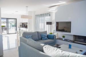 a living room with a couch and a tv at Deluxe Villa - By SCH in Salir do Porto