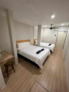 a bedroom with two beds and a mirror at Homestay Suria in Kuala Kangsar