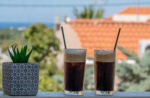 twee glazen frisdrank op een tafel met een vaas bij Casa di Kasta, in Hersonissos in Agrianá