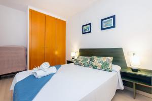 een slaapkamer met een groot wit bed en handdoeken bij RNET - Port Canigo 220 - Roses Costa Brava in Roses