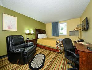 ein Hotelzimmer mit einem Bett, einem Schreibtisch und einem Stuhl in der Unterkunft Super 8 by Wyndham Minot Airport in Minot