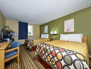 ein Hotelzimmer mit einem Bett und einem Schreibtisch in der Unterkunft Super 8 by Wyndham Minot Airport in Minot