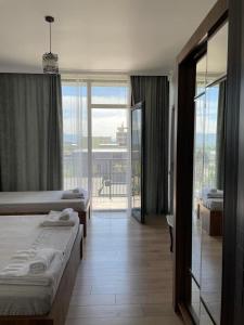 een hotelkamer met 2 bedden en een balkon bij Cozy Rooms in Kobuleti