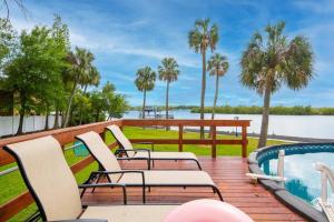 une terrasse avec des chaises, une piscine et des palmiers dans l'établissement Waterfront Paradise on Tampa Bay with Pool, à Riverview