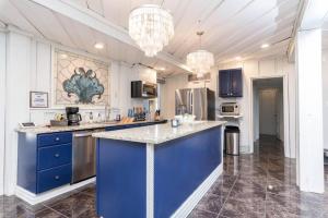 a large kitchen with blue cabinets and a blue island at Huge Waterfront Mini-Resort with Gym, Dock and Pool in Riverview +41 photos
