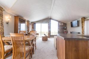 uma cozinha e sala de jantar com mesa e cadeiras em Luxury Lodge With Stunning Sea Views At Hopton Haven Park Ref 80055s em Great Yarmouth