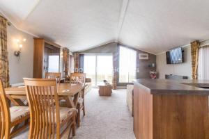 a kitchen and dining room with a table and chairs at Luxury Lodge With Stunning Sea Views At Hopton Haven Park Ref 80055s in Great Yarmouth