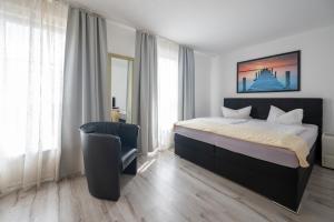 una camera con un letto e una sedia di Hotel Ammerland garni a Wilhelmshaven