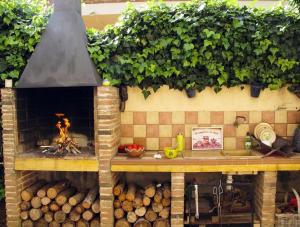 een keuken met een open haard en houtblokken bij Preciosa villa cerca playa Gran jardín piscina privada vallada y barbacoa Wifi in Tarragona