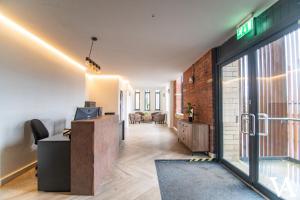 an office with a reception desk and a brick wall at Velvet Apartments - Conditioning House in Bradford