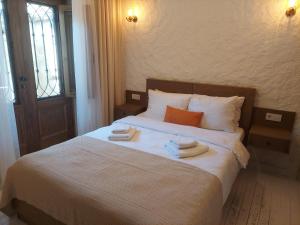 a bedroom with a bed with two towels on it at Perla Rossa Alacati in Alacati