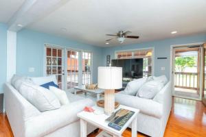 una sala de estar con 2 sofás blancos y una mesa. en Tampa Bay Getaway with Pool & Boat en Riverview