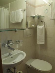 ジュネーヴにあるホテル アストリアのバスルーム(洗面台、トイレ、鏡付)