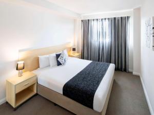 a hotel room with a large bed and a window at Mantra Castle Hill Sydney, an Accor Hotel in Castle Hill
