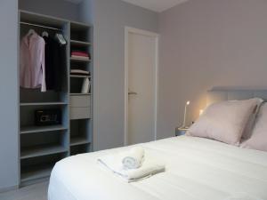 um quarto com uma cama branca e um closet em Studios Albri em Nogent-sur-Marne