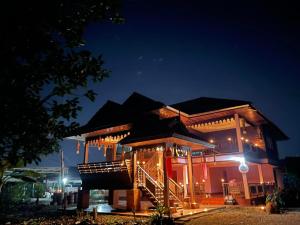 un bâtiment avec un escalier devant lui la nuit dans l'établissement House Lamphun Thai style, Near ChiangMai Airport, 