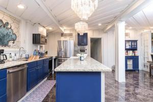 una gran cocina con armarios azules y una lámpara de araña en Stunning Tampa Bay Waterfront House with Pool en Riverview