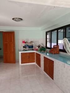 - une cuisine avec des placards en bois et un comptoir dans l'établissement House Lamphun Thai style, Near ChiangMai Airport, 