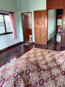 - une chambre avec un lit et un tapis au sol dans l'établissement House Lamphun Thai style, Near ChiangMai Airport, 