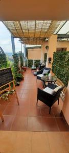 eine Terrasse mit Stühlen, Tischen und Pflanzen in der Unterkunft La mansarda suite in Benevento