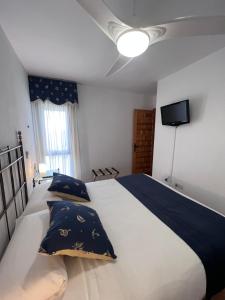 a bedroom with a large white bed with blue pillows at Apartamento Zahara in Zahara de los Atunes