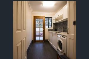 a kitchen with a washer and dryer next to a door at Kangoo - Peacefull tree lined property, wildlife in Mount View