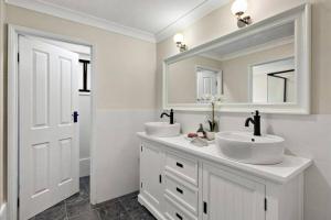 a white bathroom with two sinks and a mirror at Kangoo - Peacefull tree lined property, wildlife in Mount View
