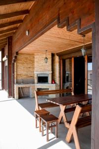 une terrasse en bois avec une table et des bancs en bois dans l'établissement Villa SeaZone, à Zatoka