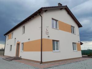 a white building with orange and white paint on it at Akacja 