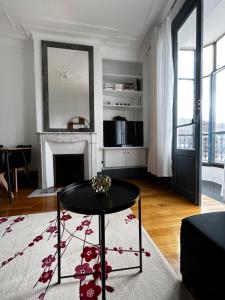 - un salon avec une table et une cheminée dans l'établissement superbe appartement belifontain coeur de ville, à Fontainebleau