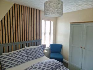 a bedroom with a bed and a blue chair at The Trelinda Guest House in Newquay