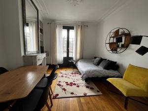 a living room with a bed and a table at superbe appartement belifontain coeur de ville in Fontainebleau