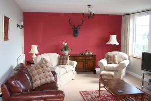 a living room with red walls and white furniture at StoneyAcre in Keswick