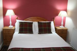 a bedroom with a bed with two lamps on night stands at StoneyAcre in Keswick