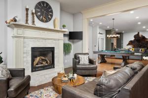 a living room with a fireplace and a pool table at Punkin Manor in Newberg