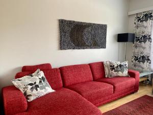 a living room with a red couch with pillows at Apartments Tähtitahko in Tahkovuori