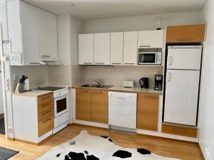 a kitchen with white appliances and wooden cabinets at Apartments Tähtitahko in Tahkovuori