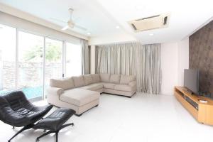 een woonkamer met een bank en een tv bij GeorgeTown PrivatePool Snooker 25Pax BBQ in George Town