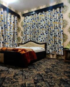 a bedroom with a bed and curtains in a room at Hotel Fabulous Kashmir in Srinagar