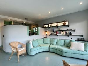 a living room with a green couch in a room at La Pineda I 1 3-6 in L'Estartit