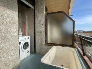 a bathroom with a tub and a washing machine at La Pineda I 1 3-6 in L'Estartit