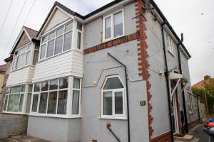 uma casa branca com muitas janelas em Wave Stays - Ground Floor Apartment em Cleveleys