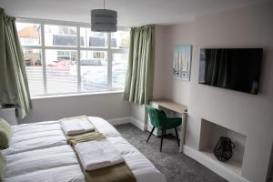 a bedroom with a bed and a desk and a television at Wave Stays - Ground Floor Apartment in Cleveleys