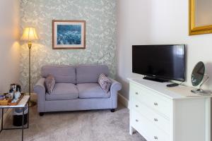 a living room with a couch and a flat screen tv at Sefton Court in Llandudno