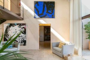 un pasillo con 2 sillas y una pintura en la pared en Premier Villa Rental in Mallorca Es Barranc Vell, en Pòrtol