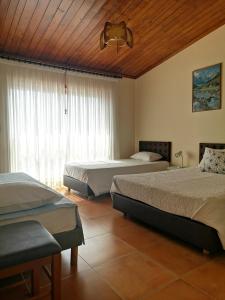 um quarto com 2 camas e um tecto de madeira em ''O Veleiro'' Rest. Resid. em Torreira