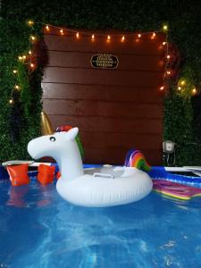 un flotador inflable de unicornio en una piscina en Teratak Hannani Maryam Kampar ( Muslim Homestay) en Kampar
