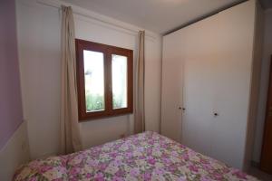 a bedroom with a bed and a window at Bilocale SABBIA 3 - Zona mare con terrazza, clima e posta auto in Marina di Campo