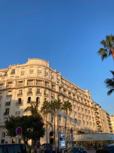ein großes Gebäude mit Palmen davor in der Unterkunft Palais Miramar in Cannes