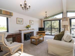 Manor Farm Lodge في ساليزبري: غرفة معيشة مع أريكة وكرسي ومدفأة